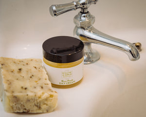 Image of Rose Petals Day Cream by Willow & Birch Apothecary beside a handmade soap on a bathroom sink, embodying best face moisturizer for dry skin and the top selection of natural face moisturizers.