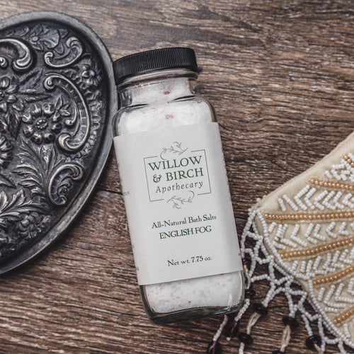 Elevate your spa bath experience with Willow & Birch Apothecary’s English Fog scented all natural bath salts, captured beside an ornate silver mirror, enhancing the soothing Epsom salt benefits. Perfect for a relaxing spa salt bath, these mineral salt bath products are ideal for therapeutic relaxation.