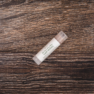 Willow and Birch Apothecary Café Mocha natural lip balm on a wooden surface, illustrating the best tasting lip balm and cocoa butter lip therapy for moisturizing chapped lips.