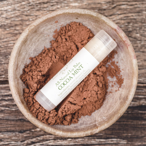 Willow and Birch Apothecary Cocoa Mint all natural lip balm resting in a bowl of cocoa powder, emphasizing the best tasting lip balm and lip butter balm for dry, cracked lips.