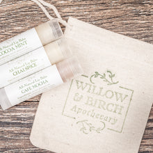 A trio of the best natural lip balm for daily use, featuring Cocoa Mint, Chai Spice, and Café Mocha flavors, displayed with a Willow & Birch Apothecary pouch.