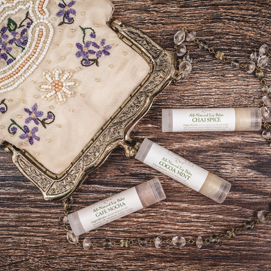 Elegant vintage clutch with Cocoa Mint, Chai Spice, and Cafe Mocha natural lip balm sticks or chapstick, highlighting the best lip balms for dry lips and best lip balm for cracked lips.