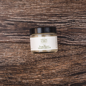 Close-up of Willow and Birch Apothecary’s Sweet Dreams Night Cream jar on a rustic wooden background, an essential oil-rich cream aging solution and the best wrinkle cream and anti aging wrinkle cream.