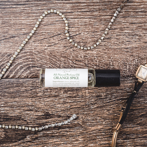 Orange Spice essential oil perfume alongside vintage pearl jewelry, showcasing a luxurious natural perfume fragrance option from Willow & Birch Apothecary.
