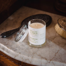 Scented soy candle by Willow & Birch Apothecary with antique mirror and brush on marble vanity