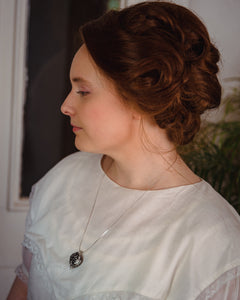 Woman in white Victorian dress wearing antique-style aromatherapy scent locket perfume locket by Willow & Birch Apothecary
