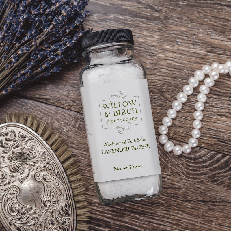 Lavender Breeze scented natural bath salts botanical epsom soak made with essential oils by Willow & Birch Apothecary with lavender bouquet, antique hair brush and antique pearl necklace