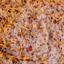 Close-up of colorful Epsom salt bath mix with vibrant flecks of orange and yellow, showcasing its soothing properties as top therapeutic salts. Ideal for a spa salt bath, these are the best bath salts for relaxing because they’re rich in minerals.