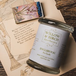 Lavender Breeze natural scented soy candle made with essential oils from Willow & Birch Apothecary with antique mirror and antique style matchbook on antique book page